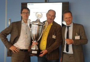 Ben Wammes, wagenparkbeheerder bij Gispen krijgt de bokaal overhandigd van Serge van den Berg van Prodrive Learning en Arjen Struijk van Climate Neutral Group.